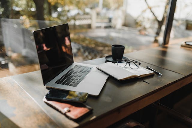 a desk with a laptop and notebook