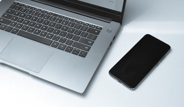 a laptop and a phone on a desk