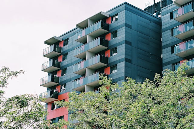 a modern apartment behind a line of trees